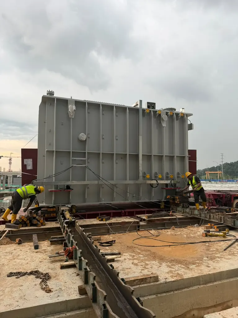 Controlled transformer unloading and positioning during an industrial relocation project.