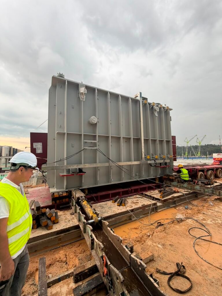 A large transformer moving along a prepared positioning path at a data centre construction site.